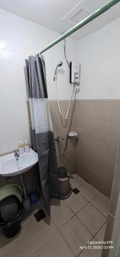 un baño con ducha y lavabo en Northpoint CozyHome, en Davao City