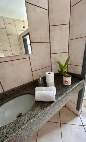 a bathroom with a bath tub and a mirror at Quarto confortável em Imbituba in Imbituba