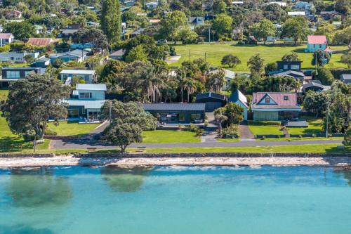 an aerial view of houses and the water at The Golden Pohutukawa - Beach House in Blackpool