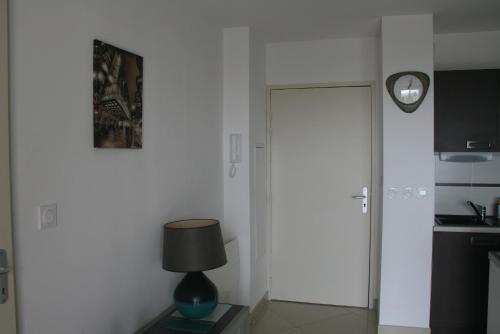 une chambre avec une porte et une lampe sur une table dans l'établissement T2 moderne avec terrasse a 100m de la plage et parking sécurisé 4 PERS MAXI, à Saint Pierre La Mer