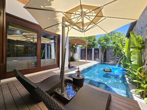 a patio with an umbrella and a swimming pool at Cy sea villa 3 in Da Nang