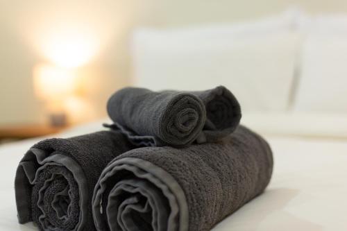 a pile of towels sitting on top of a bed at Comfy Corner Hotel in Chiang Mai