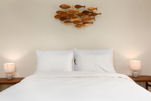 a bedroom with a bed with white sheets and shells on the wall at Comfy Corner Hotel in Chiang Mai