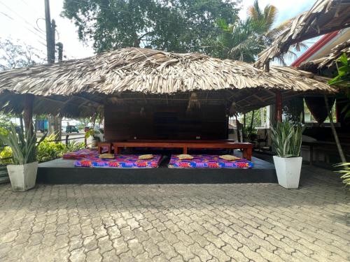a bench with a straw umbrella and some food at New Golden Bay Resort Weligama in Weligama