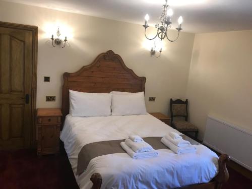 a bedroom with a bed with two towels on it at Great Trethew Hotel - Self Catering Lodges - Bar & Restaurant in Liskeard