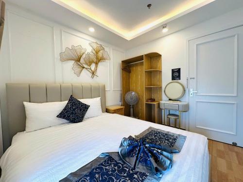 a bedroom with a bed with a blue ribbon on it at Hạ Tím Villa in Xuan An
