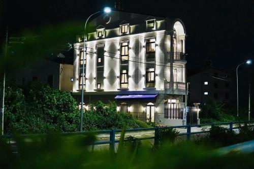 a large white building with lights on it at night at Hạ Tím Villa in Xuan An