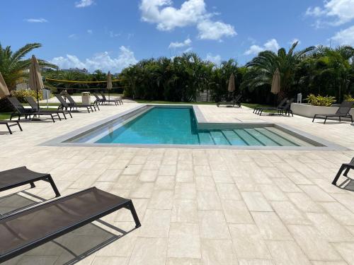 a swimming pool with lounge chairs and a patio at Ocean&airport view condo with pool&gym in Maho, walk to Maho Beach and Mullet Bay in Maho Reef