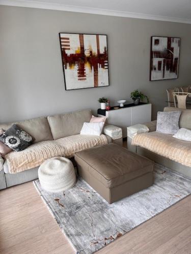 a living room with a couch and a ottoman at Seaside Escape Rockingham in Rockingham