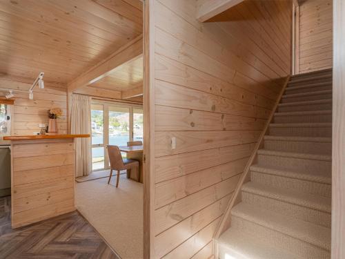 a staircase in a house with wooden walls at Waterfront Paradise - Pauanui Holiday Home in Pauanui