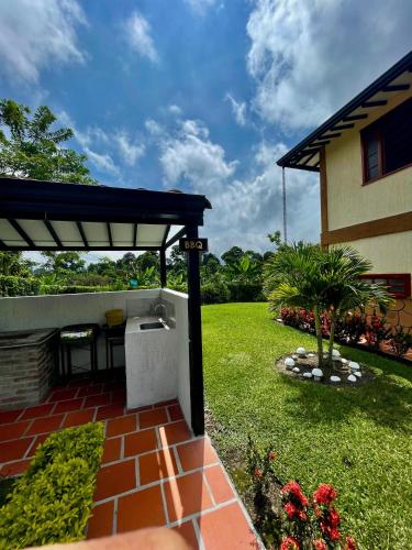 a patio with awning next to a house at Hotel Campestre Villa Salome in Quimbaya