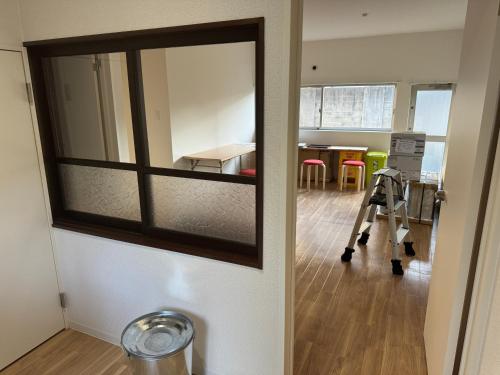 a room with a mirror and a room with a table at Self check-in Hostel 5mins from JR Nishi Hiro station in Hiroshima