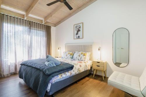 a bedroom with a bed and a mirror and a window at Bayview Escape McCrae in McCrae