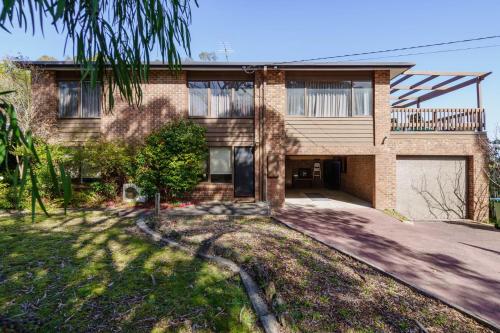 a brick house with a driveway in front of it at Bayview Escape McCrae in McCrae