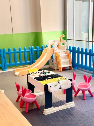 a childs play area with a slide and chairs at Holiday Inn Quanzhou Donghai by IHG in Quanzhou