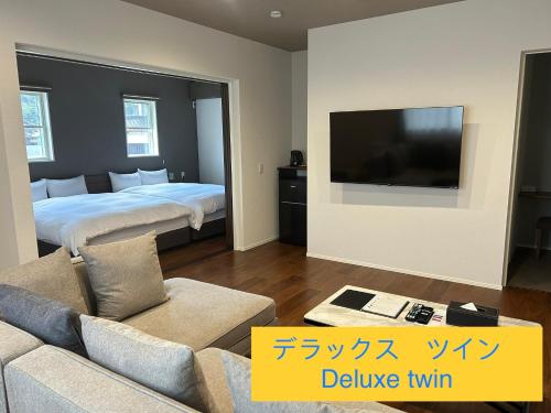 a living room with a bed and a television at Wright Style ANNEX in Naoshima