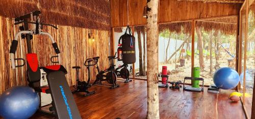 a gym with many exercise equipment in a room at Hotel Kin Tulum Jungle Deluxe in Tulum