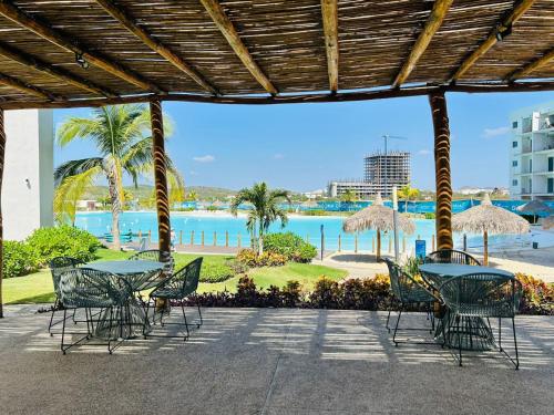 a patio with tables and chairs and a view of the ocean at alberca tipo playa,10 min de la playa by G P S rentas in Mazatlán