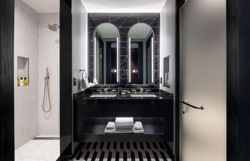 伯明翰Daxton Hotel Birmingham, Curio Collection by Hilton的带水槽和镜子的浴室