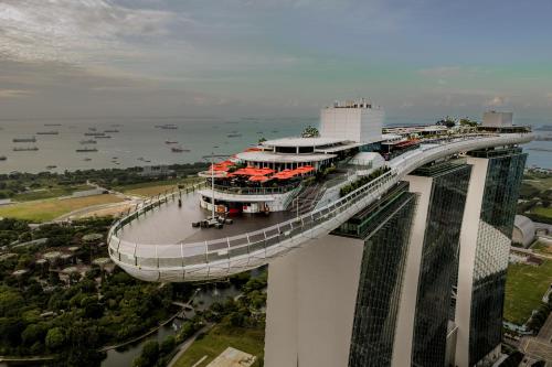 eine erhöhte Aussicht auf ein Gebäude mit einer Brücke in der Unterkunft Marina Bay Sands in Singapur