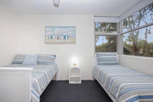 En eller flere senge i et værelse på Beachfront on Bennetts Beaches Apartment 4