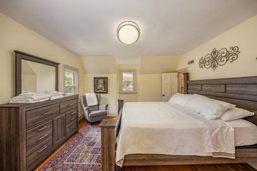 a bedroom with a bed and a dresser and a mirror at Harrisonburg Hidden Gem Across from JMU & Hotspots in Harrisonburg