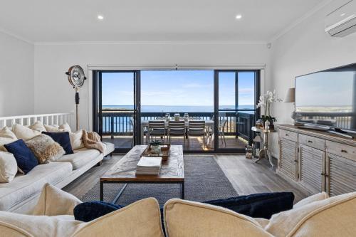 a living room with a couch and a table at Shoreline Escape in Wirrina Cove