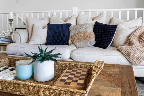 a living room with a white couch with pillows at Shoreline Escape in Wirrina Cove