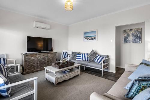 a living room with a couch and a tv at Shoreline Escape in Wirrina Cove