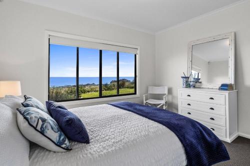 a bedroom with a bed and a large window at Shoreline Escape in Wirrina Cove