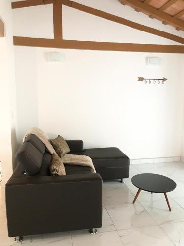 a living room with a black couch and a table at City Apartment in Caacupé