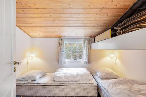 - 2 lits dans une chambre dotée d'un plafond en bois dans l'établissement Beautiful Holiday Home With Panoramic Views Over Ebeltoft Bay, à Ebeltoft