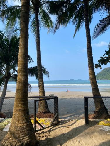 a beach with palm trees and a volleyball net at EL Nido Bucana Beach House in El Nido