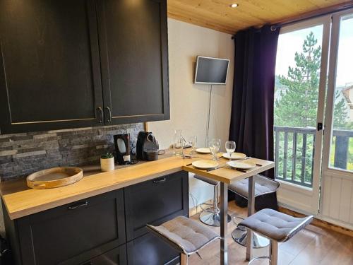 une cuisine avec une table avec des verres à vin dessus dans l'établissement Studio confortable proche ESF - Balcon exposé ouest - FR-1-266-237, à Montgenèvre