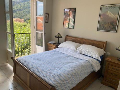 - une chambre avec un lit et un balcon dans l'établissement Bel F3 en centre-ville avec balcon et parking, proche cures - FR-1-703-196, à Amélie-les-Bains-Palalda