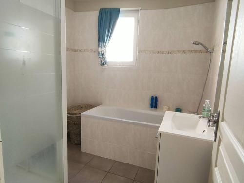 une salle de bain avec une baignoire, un lavabo et une fenêtre dans l'établissement Bel F3 en centre-ville avec balcon et parking, proche cures - FR-1-703-196, à Amélie-les-Bains-Palalda
