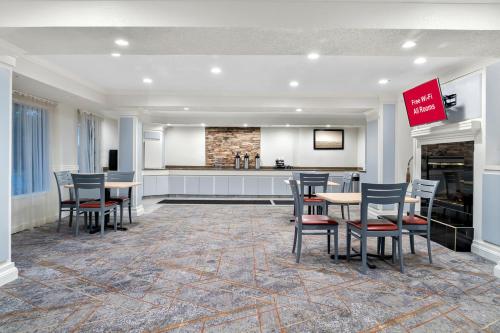 a room with tables and chairs and a kitchen at Red Roof Inn Auburn Hills in Auburn Hills