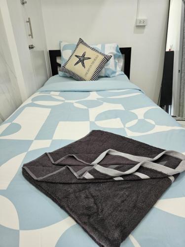 a bedroom with a bed with a blanket on it at Haru Inn Airport in Ban Bo Han