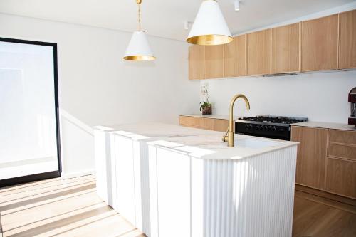 a kitchen with white cabinets and a sink at Coco Queen in Paarl