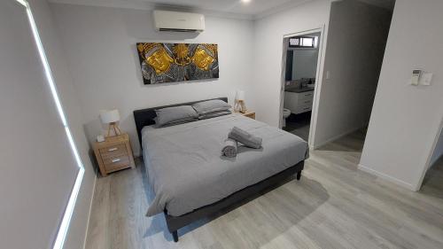 a bedroom with a bed and a painting on the wall at Bali Elliott Heads - Coastal Holiday Home near Boat Ramp in Elliott Heads