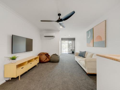 a living room with a couch and a flat screen tv at Elsinor 6 in Mulwala