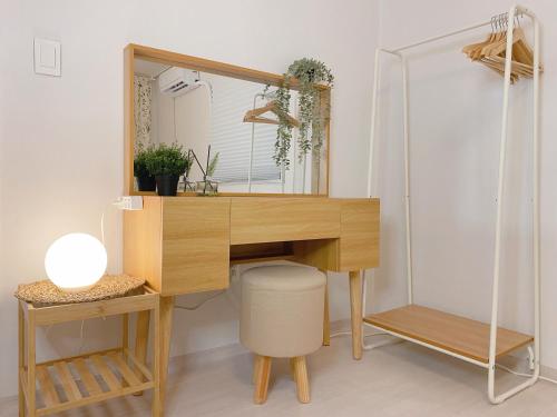 a wooden desk with a mirror and a stool at Sha lala stay in Seoul