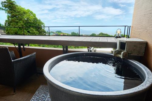 a bath tub on the balcony of a building at 伊豆高原 記念日を祝う宿 自然家 Haco しぜんや ハコ in Ito