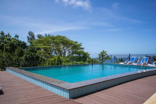 a swimming pool with two lounge chairs on a deck at Amanda Villa - Best Value Mountain top Inn in Au Cap