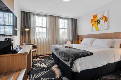 a hotel room with a bed and a television at Prince of Wales Hotel in Hobart