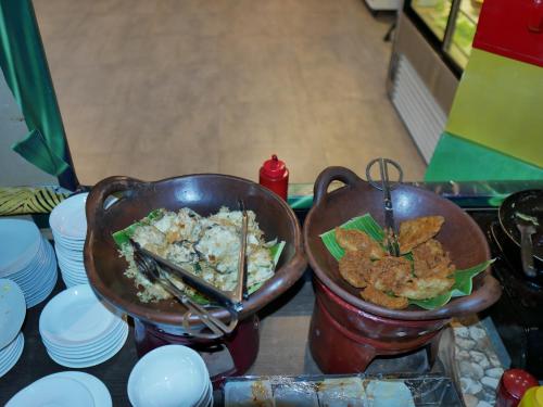 a pot of food and a bowl of food with chopsticks at Meotel Purwokerto in Purwokerto