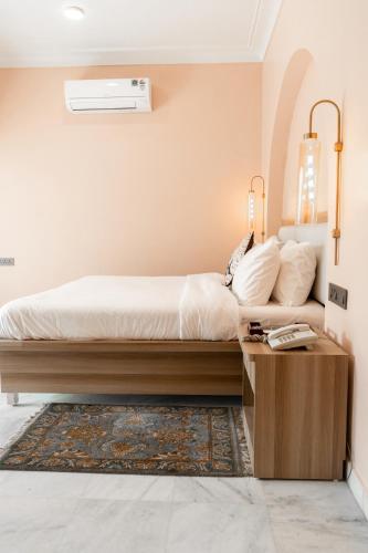 a bedroom with a bed and a table with a phone at Girisadan Boutique Stay in Jaipur