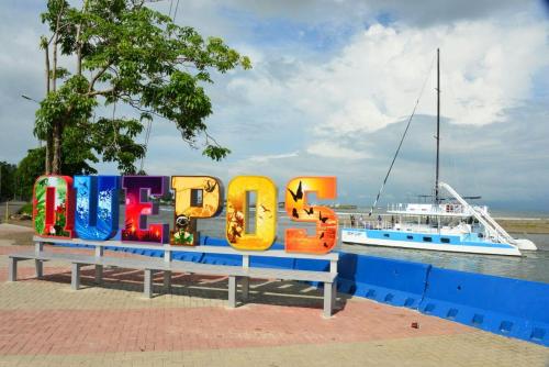 a bench with a sign that reads dive next to a boat at Tropical Twins Apartment in Quepos