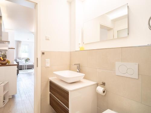 a white bathroom with a sink and a mirror at UNS MUUSLOCK in Ahrenshoop