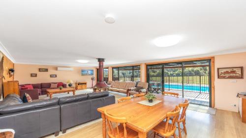 a living room with a couch and a table at Barkeldine Farm Country Retreat in Bucca-Wauka